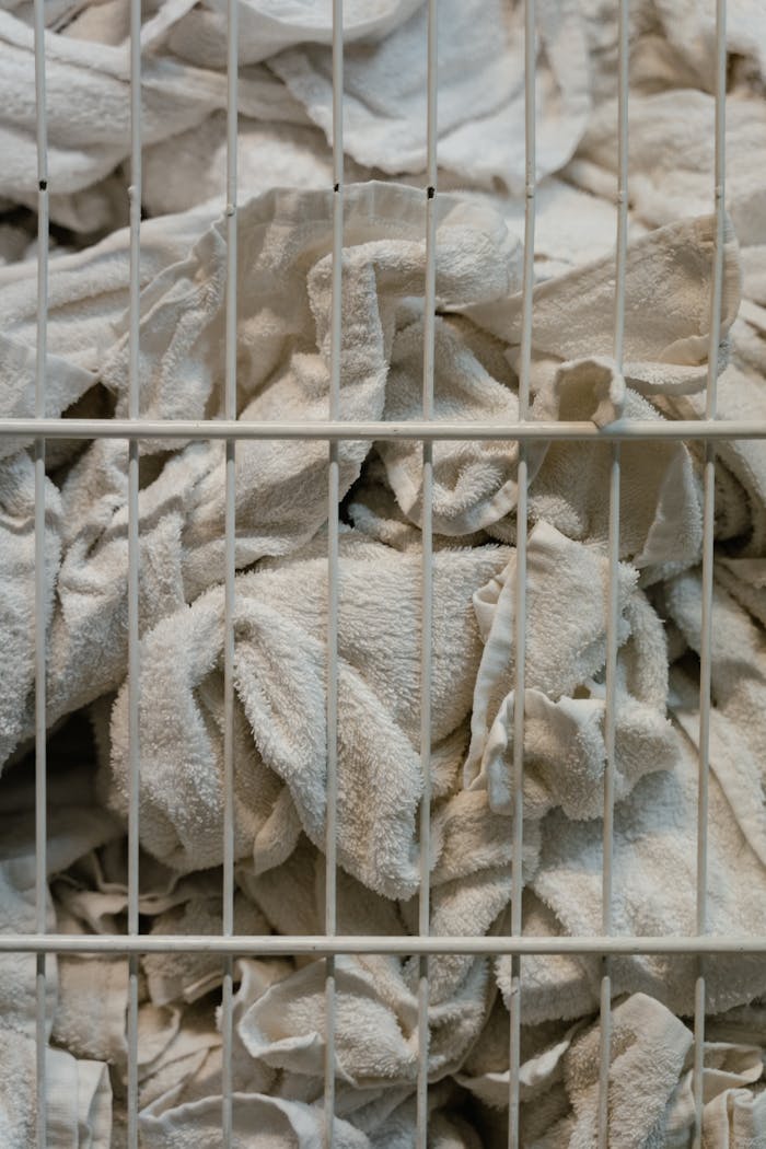 Close-up of white towels in a basket, highlighting textures and industrial setting.