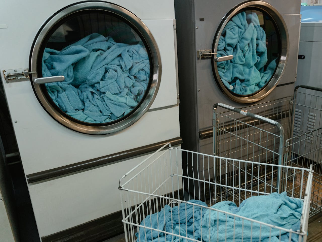 Industrial washing machines with blue towels in a laundry facility.